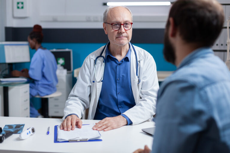 Doctor doing medical consultation with patient in cabinet